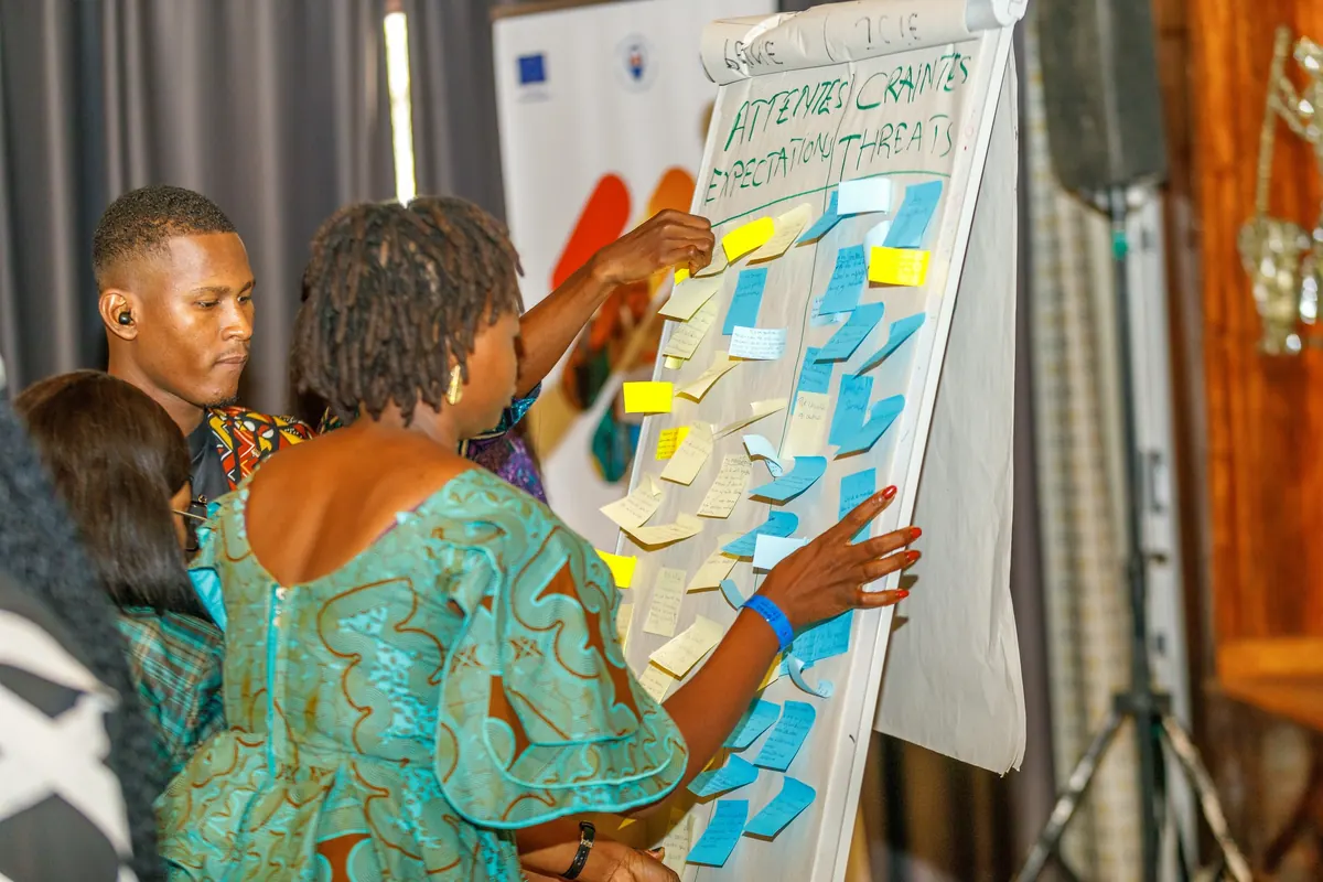 Atelier participatif : des participants collent des notes sur un tableau